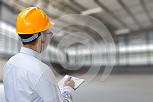 Male engineer checking in factory With note on notepad or industry