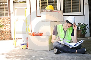 Male engineer inspecting the house Sit and look at the construction plan to check the details