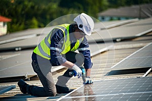 Male engineer maintaining solar cell panels on building rooftop. Technician working outdoor on ecological solar farm construction.