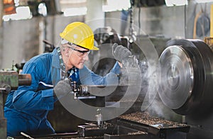 Male engineer metalworker operating workpiece for prototype product at a factory