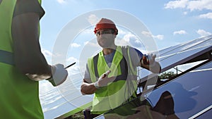 Male engineer showing photovoltaic panel to inspector