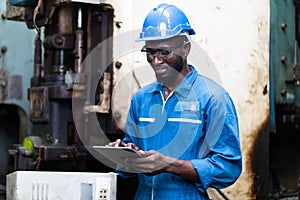 Male Engineer Working on digital tablet in Factory. black male engineer checking Quality control the condition of the machine