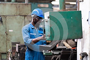 Male Engineer Working on laptop computer in Factory. black male engineer checking Quality control the condition of the machine.
