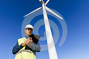 Male engineer working in a wind turbine field.