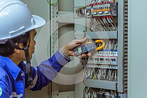 Male engineers are checking the electrical system with electronic tools, clamp-on, clip amp ,clamp meter