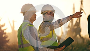 Male engineers in hardhats are discussing a project