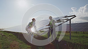 Male engineers installing solar panels together