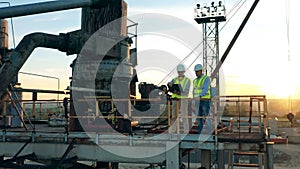 Male engineers are looking around the river port from above