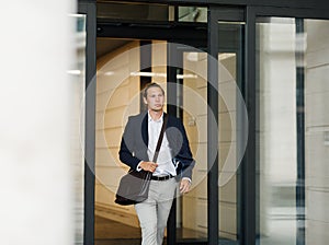 Male entrepreneur exiting from office building