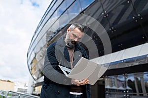 male entrepreneur working online on a laptop before boarding a plane at the airport