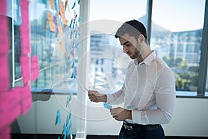 Male executive reading sticky note