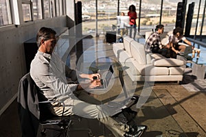 Male executive working on laptop in office