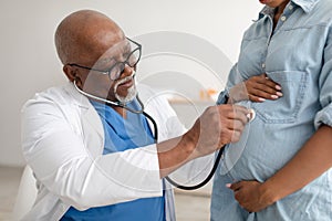 Male experienced doctor examining young pregnant woman