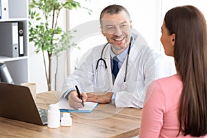 Male experienced doctor talking to his female patient
