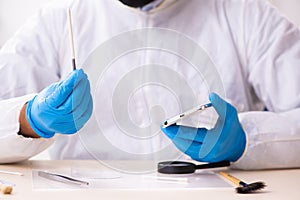 Male expert criminologist working in the lab for evidence