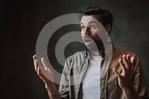 Male expressing astonishment and gesticulating hands indoor