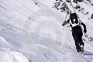 Male extreme skier heading towards a high alpine mountain peak