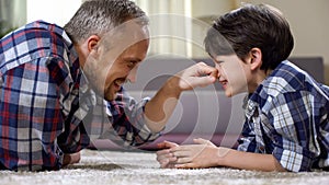 Male family playing on the floor at home, having fun together, weekend leisure