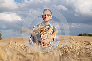 Male farmer or baker with baguettes in rye, wheat field