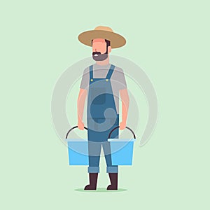 Male farmer holding water buckets gardener watering plants working in garden agricultural gardening eco farming concept