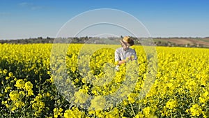 Male Farmer in Oilseed Rapeseed Cultivated Agricultural Field Examining and Controlling The Growth of Plants