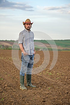 Male Farmer Standing on Fertile Agricultural Farm Land Soil