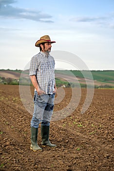 Male Farmer Standing on Fertile Agricultural Farm Land Soil