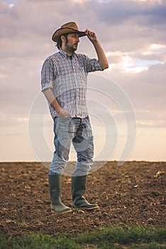 Male Farmer Standing on Fertile Agricultural Farm Land Soil