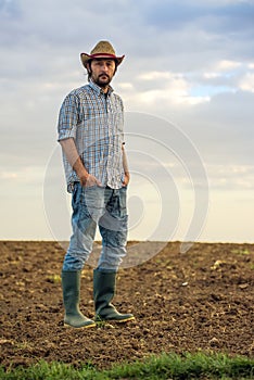 Male Farmer Standing on Fertile Agricultural Farm Land Soil