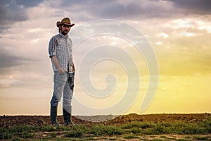 Male Farmer Standing on Fertile Agricultural Farm Land Soil