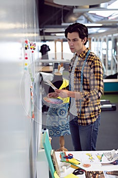 Male fashion designer looking at sketch in office