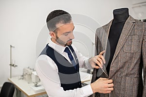 Male fashion designer undoing buttons on jacket