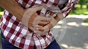 Male feeling abdominal pain outdoors, indigestion discomfort, poisoning, nausea photo
