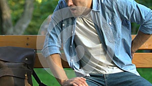 Male feeling sudden backpain sitting on bench in park, neuralgia, kidney disease