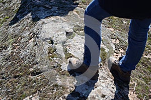 Male feet in boots.Climber on the top of rock.Relaxation after long walk