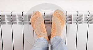 Male feet with socks on the radiator. Heating season. Home