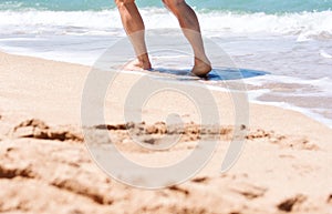 Male feet step on the sea wave. Summer vacations concept.Beach holiday