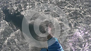 Male Feet walking on the shallow crystal Sea Water Beach Sand. Concept of relax and happiness.