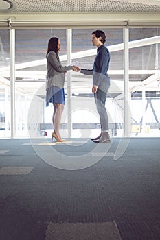 Male and female architects shaking hands with each other in office