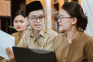 Male and female civil servants sit together chatting while working online from home