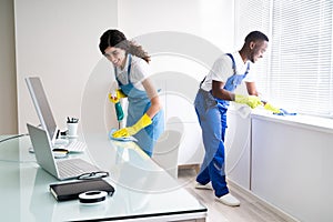 Male And Female Cleaners Cleaning Office