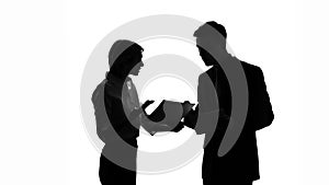 Male and female colleague silhouettes arguing over business documents at office