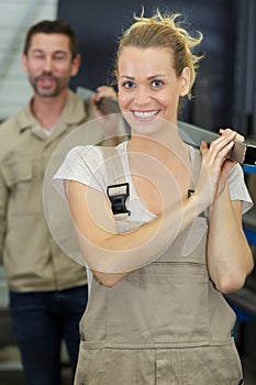 male and female colleagues carrying metal length on their shoulders