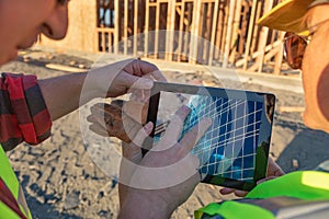 Male and Female Construction Workers Reviewing Building on Computer