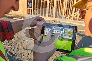 Male and Female Construction Workers Reviewing House on Computer