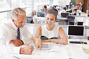 Male and female coworkers at a desk in an architect?s office