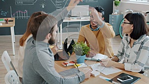 Male and female coworkers doing high-five sharing ideas working together in office