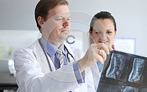 Male and female doctors carefully look at an x-ray