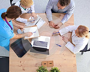 Male and female doctors working on reports in