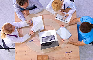 Male and female doctors working on reports in medical office